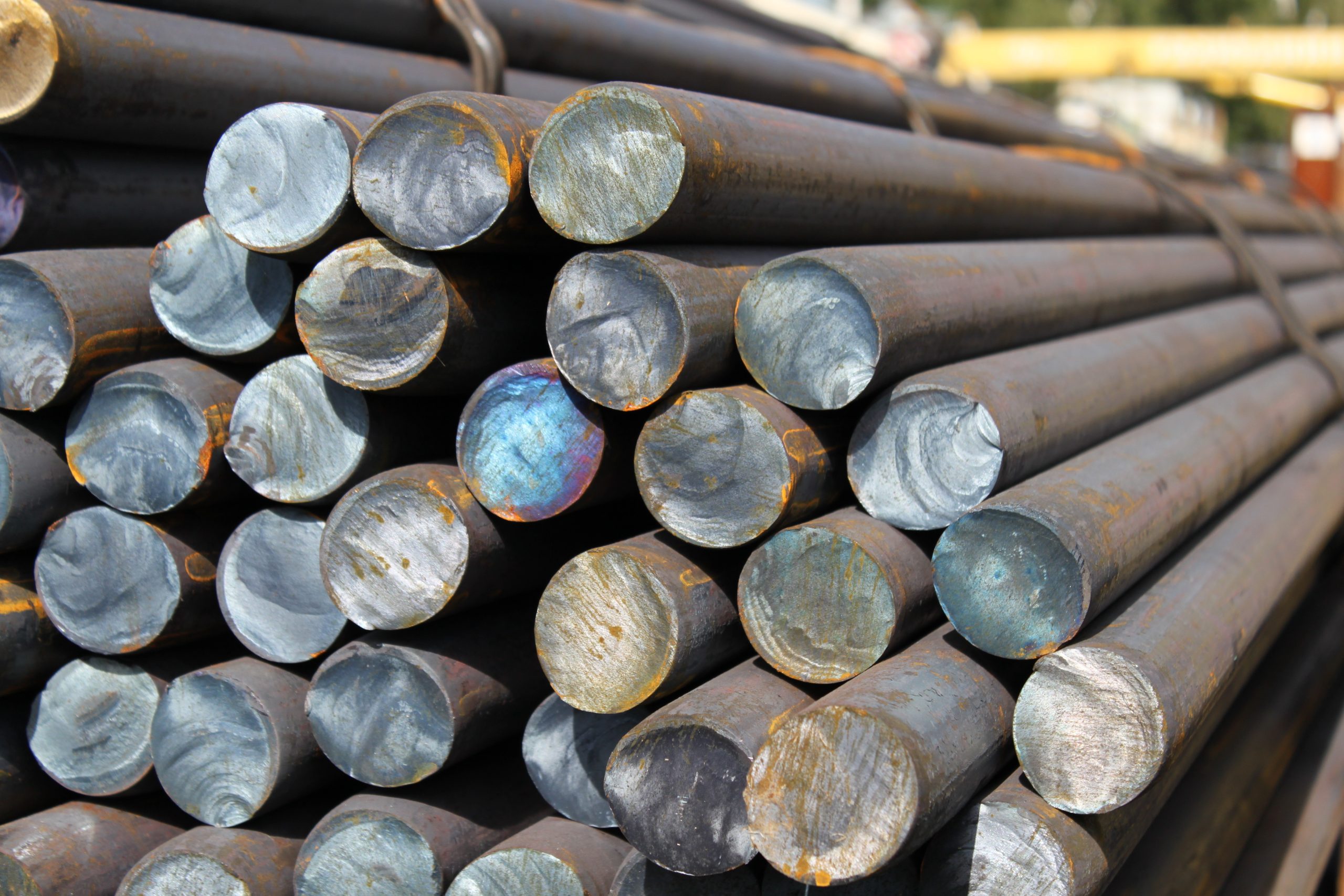 Close up of carbon steel rounded bars banded together outside .