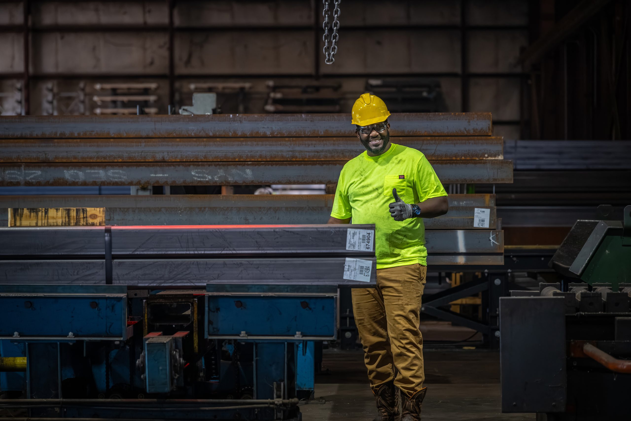 Man standing up smiling giving a thumbs up in a warehouse for Siskin Steel & Supply.