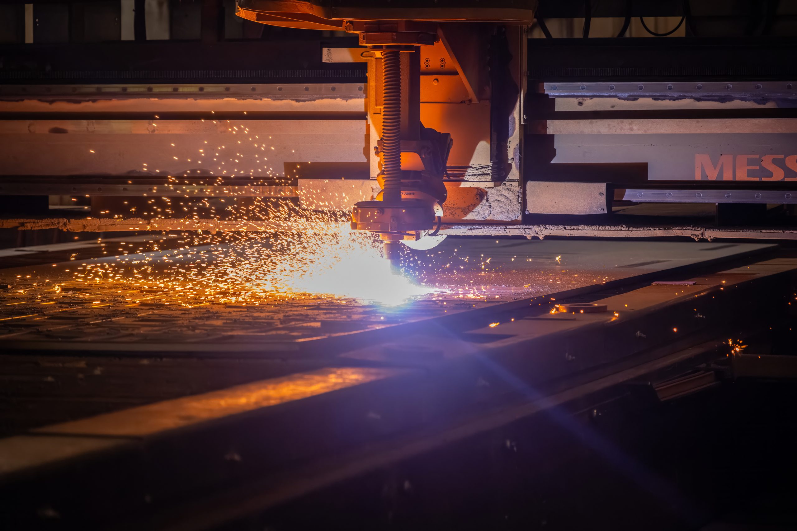 Close up of an oxyfuel flat laser creating sparks while burning a steel plate