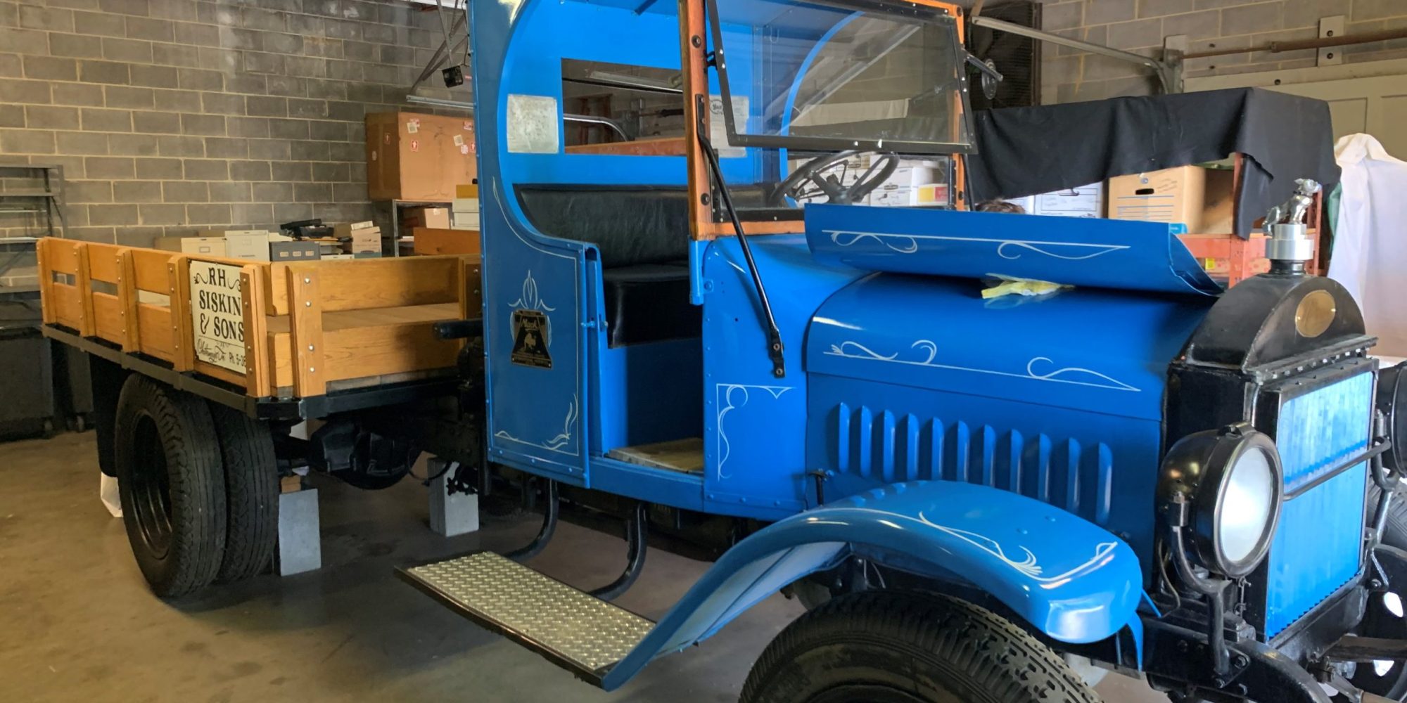 original siskin truck Photo of vintage truck with a light blue body and black accents inside of a storage facility.