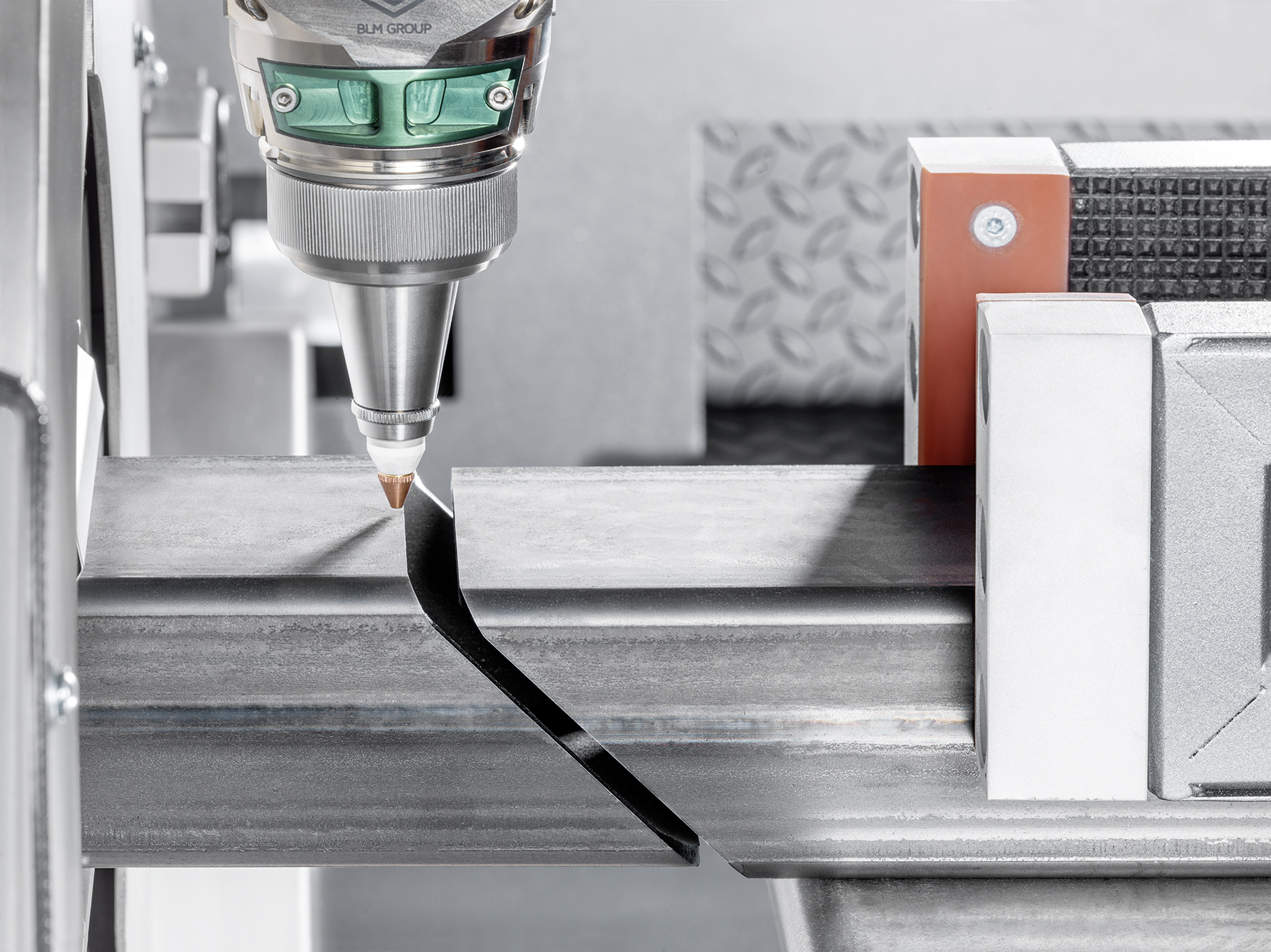 Silver laser pointing down at a piece of tubing at an angle