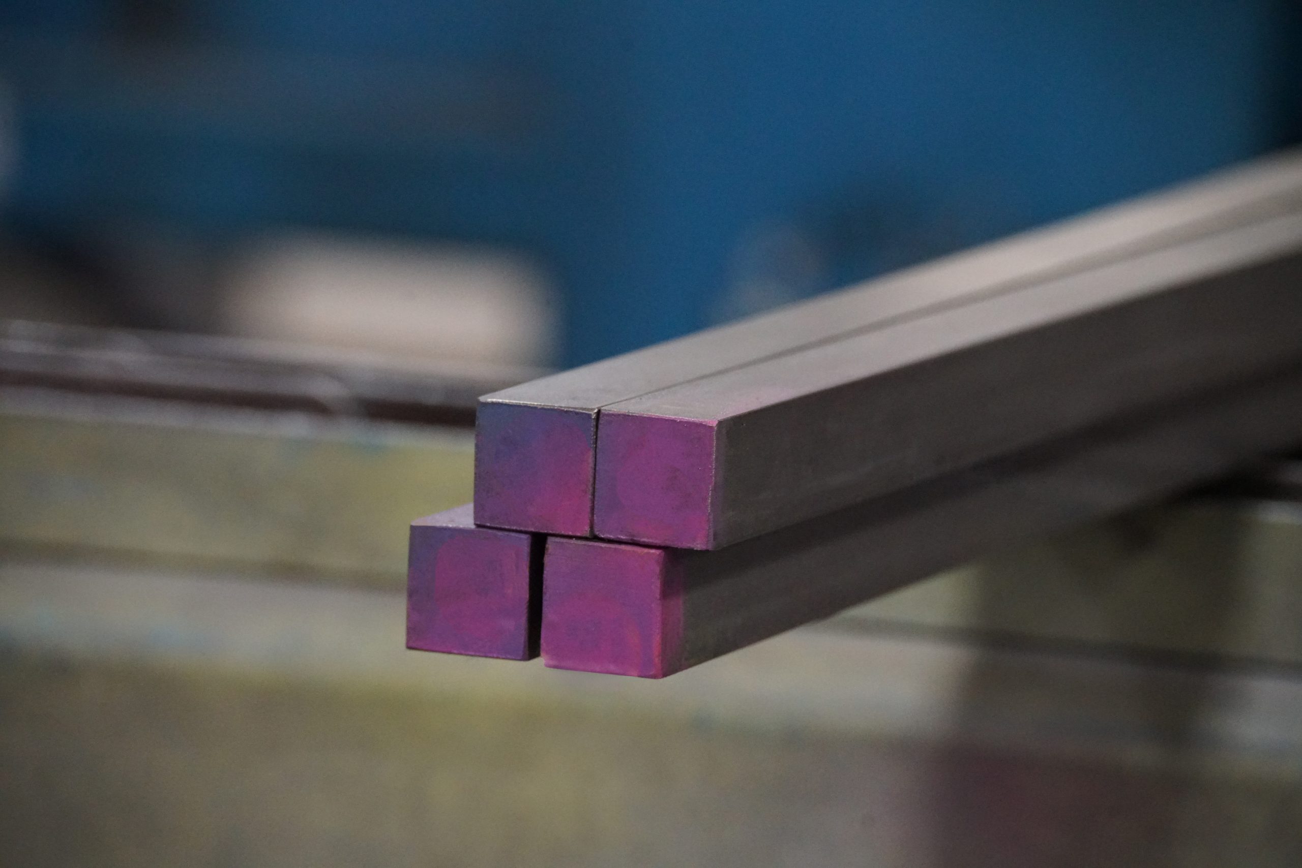 Portrait of four cold rolled square bars in a small bundle on a conveyor belt
